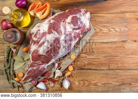 A Raw Leg Of Mutton On A Bone Lies On A Piece Of Burlap , Onions, Garlic, Pepper, Salt, Rosemary And