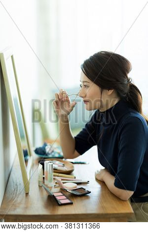 Young business woman applying make-up
