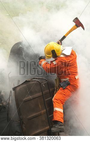 Firefighters Using Ax Destroy Obstacles In A Burning And Smoky Car.