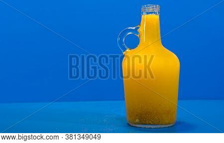 Lemonade In Glass Bottle On Blue Background