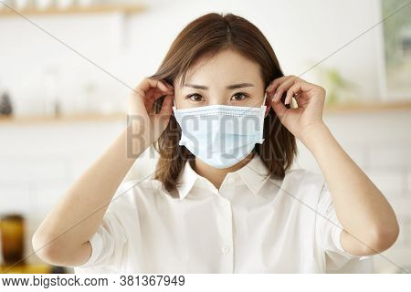 Beautiful Young Asian Woman Putting On A Mask On Face