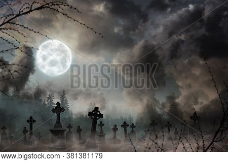Misty Graveyard With Old Creepy Headstones Under Full Moon On Halloweeen