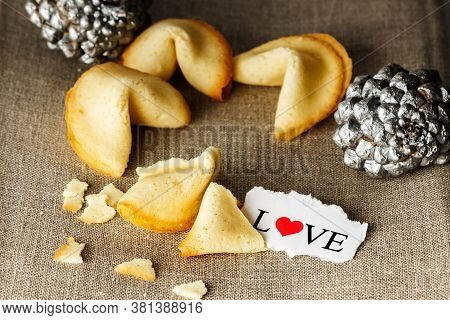 Cookies Shaped Like Tortellini With The Word Love Written On A Paper And Two Silver Pineapples In Th