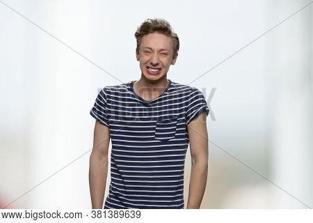 Emotional Teenage Boy Is Crying, Front View. Portrait Of Nervous Expressive Teen Boy. Emotions, Expr