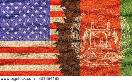Afghan and American nafghan, ational flags on the sand surface
