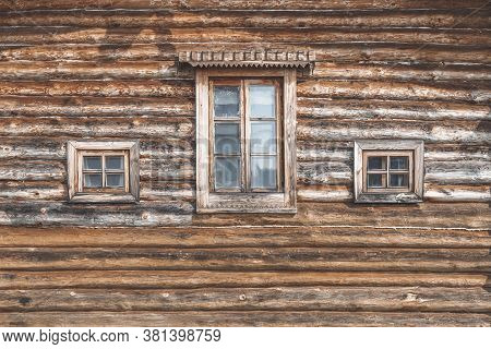 Wall Of An Old Farm Building. Natural Wooden Texture, Rural House For Agritourism, Different Windows