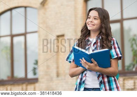 Imagine Your Dreams. Little Kid Hold Book With Thoughtful Look. Imaginative Thinking. School Time. C
