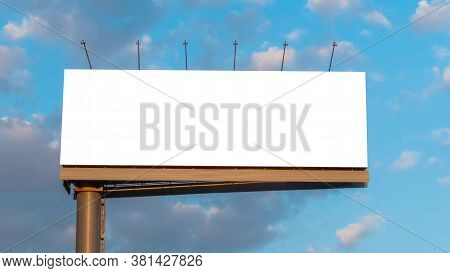 Wide Blank White Billboard Or Large Display And Clouds Against Sunset Blue Sky - Mock Up Image. Cons