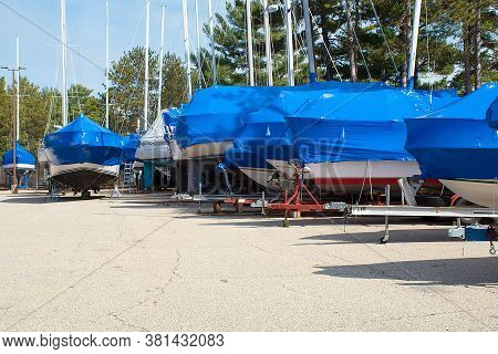Protective Blue Tarp On Boats In Michigan Outdoor Storage Lot