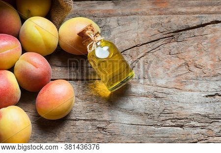 Glass Bottle Of Apricot Seed Kernel Oil ( Prunus Armeniaca Oleum ) With Fresh Ripe Apricot Fruits On