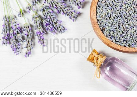Glass Bottle Of Lavender Essential Oil With Fresh Lavender Flowers And Dried Lavender Seeds On  Rust