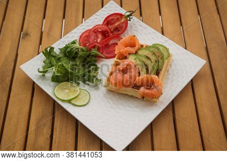 Waffle With Slices Of Salted Salmon And Avocado. The Concept Of A Healthy Breakfast.