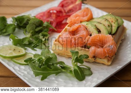 Waffle With Slices Of Salted Salmon And Avocado. The Concept Of A Healthy Breakfast.