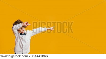 Boy Smiling And Pointing Aside Reccomending To Buy Something On Yellow Background