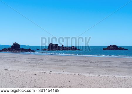 Parts Of A Reef Jutting Out Of The Sea Near The Beach At Low Tide