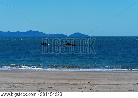 Part Of A Rocky Reef Jutting Out From The Ocean At Low Tide