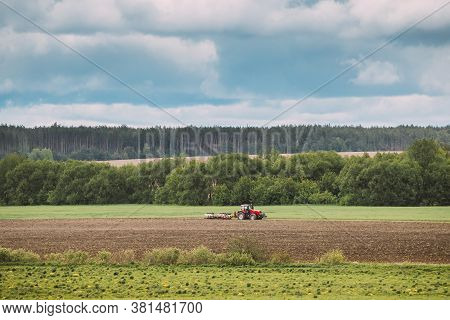Tractor Plowing Field In Spring Season. Beginning Of Agricultural Spring Season. Cultivator Pulled B