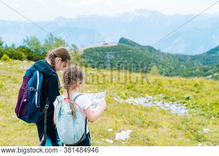Children Hiking On Beautiful Summer Day In Alps Mountains Austria Resting On Rock. Kids Look At Map 