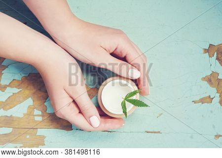 Cannabis Cream With Marijuana Leaf In Hands. Concept Of Herbal Alternative Medicine, Cbd Oil, Pharma