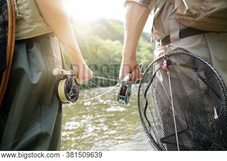 portrait of two fisherman waiting for gobings on a trout river