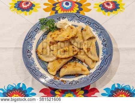 Pierogi Served On A Plate Ready For Eating With Lowicz Pattern Table Cloth
