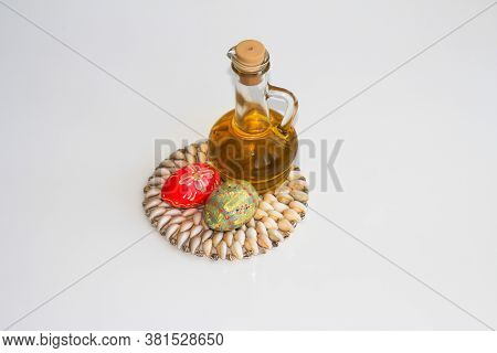 A Bottle Of Olive Oil And Two Easter Eggs On A Light Background.