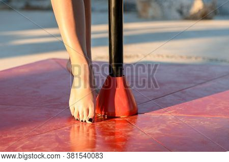Slender Nude Female Legs And Slim Feet In Pole Dance Class Outdoors At Sunset, Close Up. Pole Dancer
