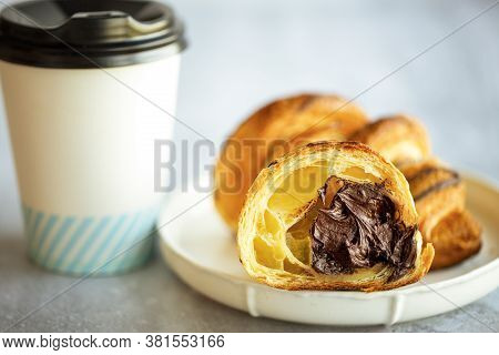 Croissant with coffee. Chocolate croissant cutaway. Chocolate flows out of the dough. The filling fl