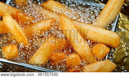 Cooking french fries in the deep fryer, crispy fries, Junk food concept