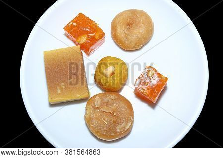 Indian Sweets Served In White Plate. Halwa, Badusha, Ghee Mysore Pak, Laddu In Decorative Plate,