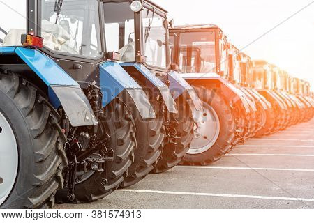 Many Different Tractors Standing In Row At Agricultural Fair For Sale Outdoors.equipment For Agricul