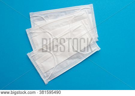 Surgical Earloop Face Mask On Blue Background. Medical Masks For Coronavirus Protection