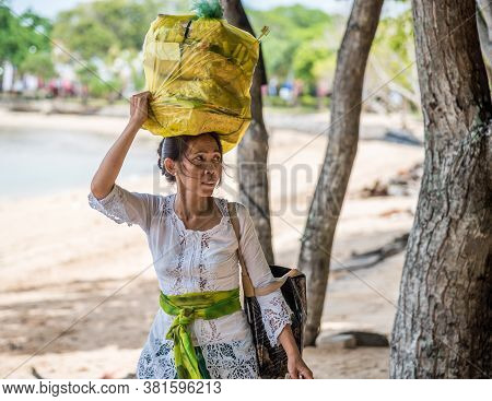 Nusa Dua, Bali / Indonesia - 11/16/2016 Local Balinese Woman Carrying Blessing Canang Trays On Her H