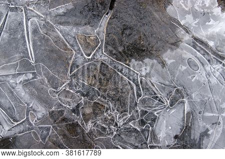 Frozen Puddle With Broken Ice. Winter Season.