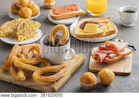 Different Spanish Breakfast, Tortilla, Bruschetta With Jamon (cured Ham) And Tomatoes, Churros With 