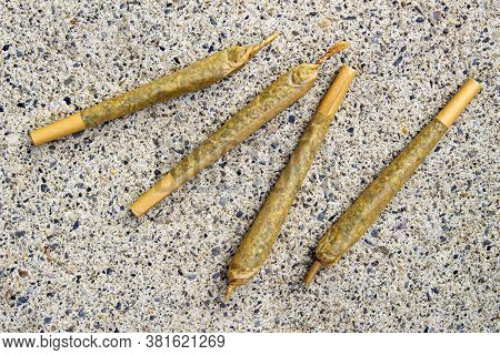 Cannabis Pre-roll Joints Cigarettes On A Concrete Texture.