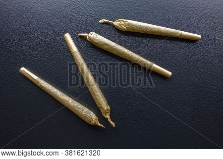 Cannabis Pre-roll Joints Cigarettes On A Leather Black Texture.
