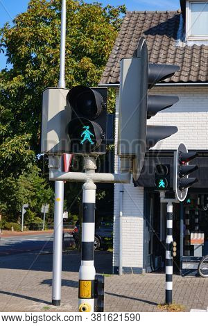 Green Pedestrian Light With A Walking Or Waiting Happy Girl With Ponytail At Crossroads In The Nethe