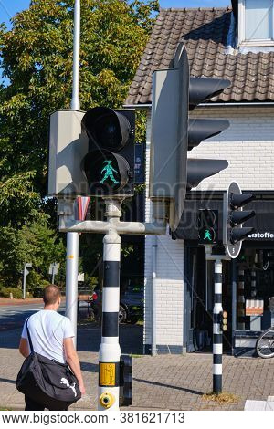 Bennekom, Netherlands, Aug, 19, 2020:green Pedestrian Light With A Walking Happy Girl With Ponytail 