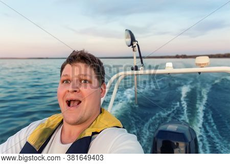 Young Adult Happy Caucasian Excied Man Portrait Enjoy Having Fun Driving Fast Motorboat On Pond Wate