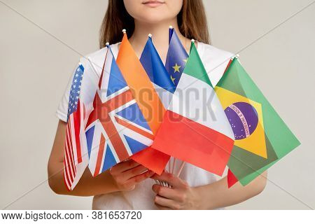 World Community. Global Organization. Woman Holding International Flags Isolated On Blur Light Backg
