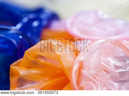 High-quality Latex Condoms In Blue, Orange, Pink, A Means To Prevent Pregnancy And Infection, Close-