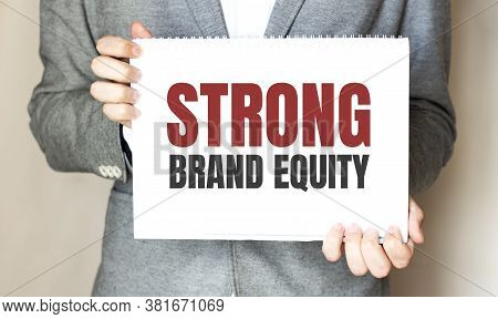 Businessman Holding A Card With Text Strong Brand Equity