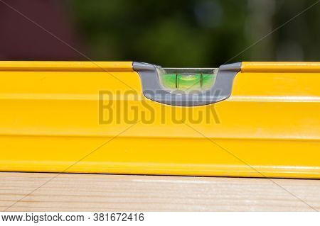 Close-up Of A Yellow Hydro Level With A Green Float Against A Blue Sky On A Summer Day During The Co