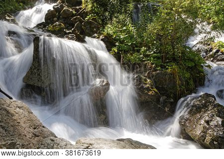 A Small Waterfall Flows On A Mountain Creek