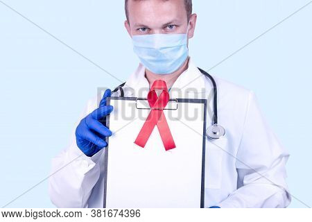 A Doctor In Medical Gloves Holds A Tablet With A Red Ribbon - A Symbol Of The Fight Against Aids And