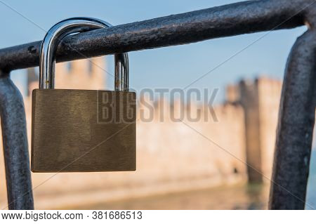 Empty Padlock On The Bridge In Sirmione, Garda Lake, Italy. The Rocca Scaligera Castle On Background