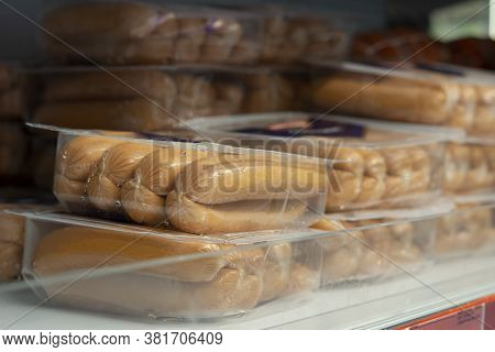 Raw Sausages In Packages On Shelves In A Retail Store. Packets Of Meat At The Supermarket