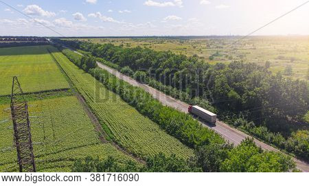 Aerial. Truck Driving By The Roadway Between Agricultural Fields.