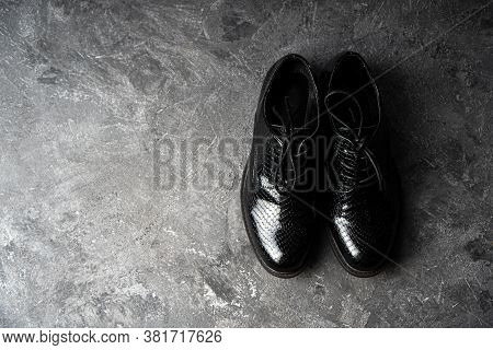 Elegant Unisex Black Shoes Standing On The Concrete Background. Top View. Copy Space.